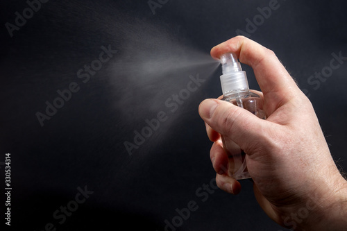 Alcohol spray from a bottle to desinfect surfaces and items. photo
