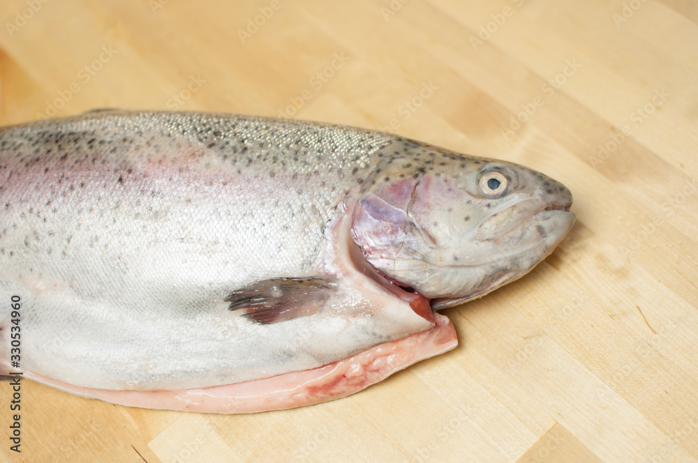 Cutting gutted red fish trout sweetfish on wood background Cutting gutted red fish trout sweetfish on wood background