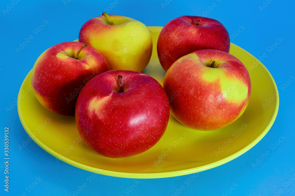 Ripe red red apples close-up isolate on a blue background. Ripe red red apples close-up isolate on a blue background.