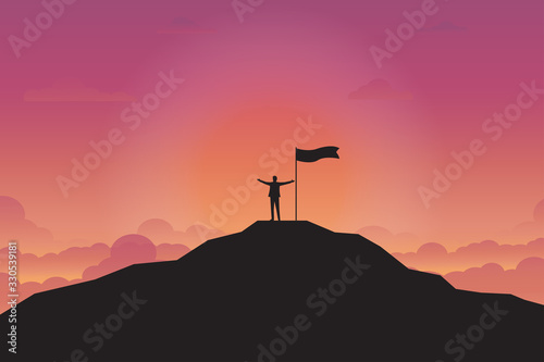 Silhouette of businessman and flag on top mountain