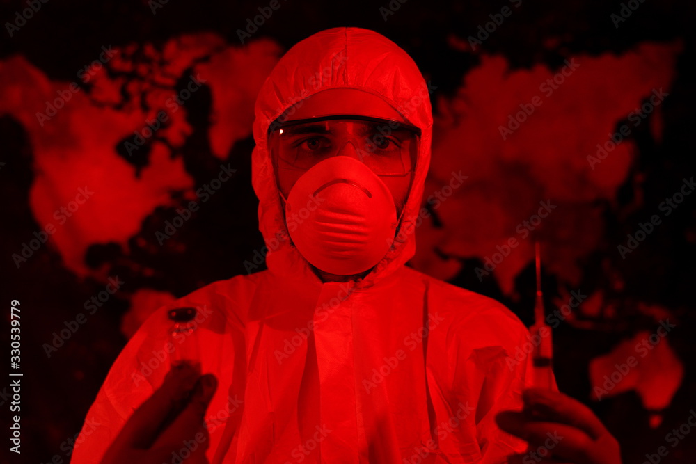 Fototapeta Man in protective suit holding bottle and syringe over map background. Development of licorice against the virus.