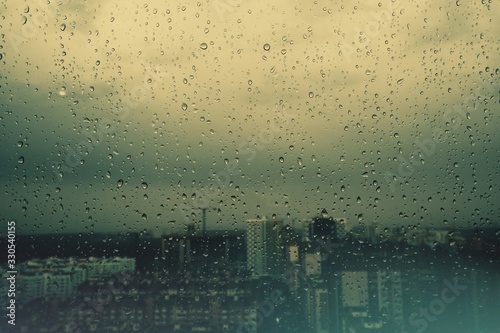 Raindrops on the glass. Cloudy weather in the city. It's a sad mood.