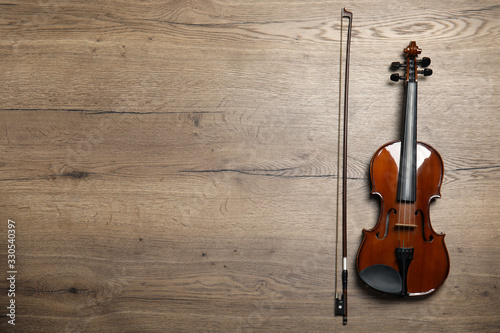 Classic violin and bow on wooden background, flat lay. Space for text © New Africa