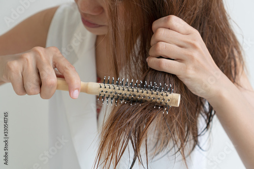 Woman brushing her wet messy hair after bath with comb, Thin hair porblem. Hair Damage, Health And Beauty Concept. photo