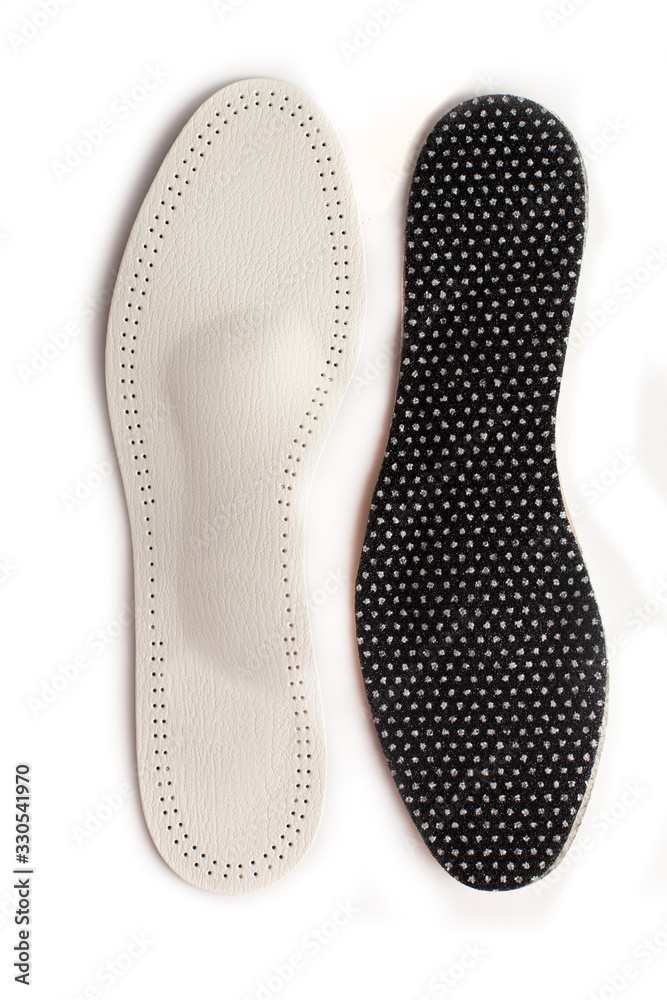 Isolated orthopedic insole on a white background. Treatment and prevention of flat feet and foot diseases. Foot care, comfort for the feet. Wear comfortable shoes. Medical insoles. Isolated orthopedic insole on a white background. Treatment and prevention of flat feet and foot diseases. Foot care, comfort for the feet. Wear comfortable shoes. Medical insoles.