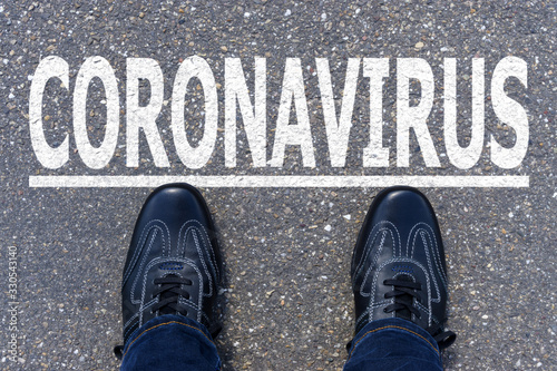 Word CORONAVIRUS written on asphalt with shoes, concept background