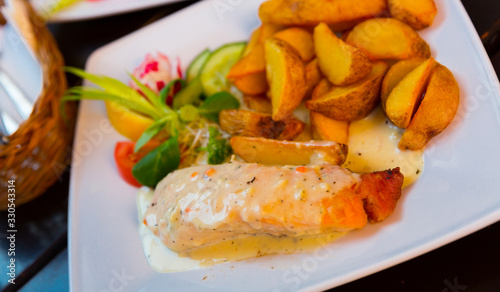 Salmon with sauce and potatoes is tasty dish
