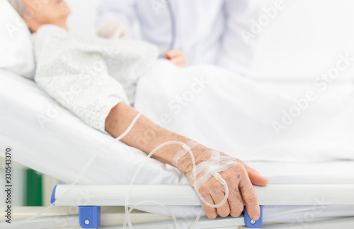 close up hand of old patient woman in hospital , old asian female sleeping on bed in hospital, wrinkle skin, solution treatment