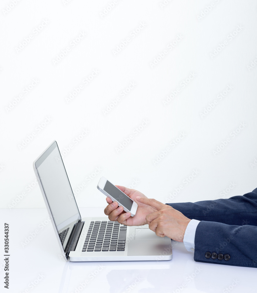 Businessman hand holding smartphone with laptop computer Businessman hand holding smartphone with laptop computer