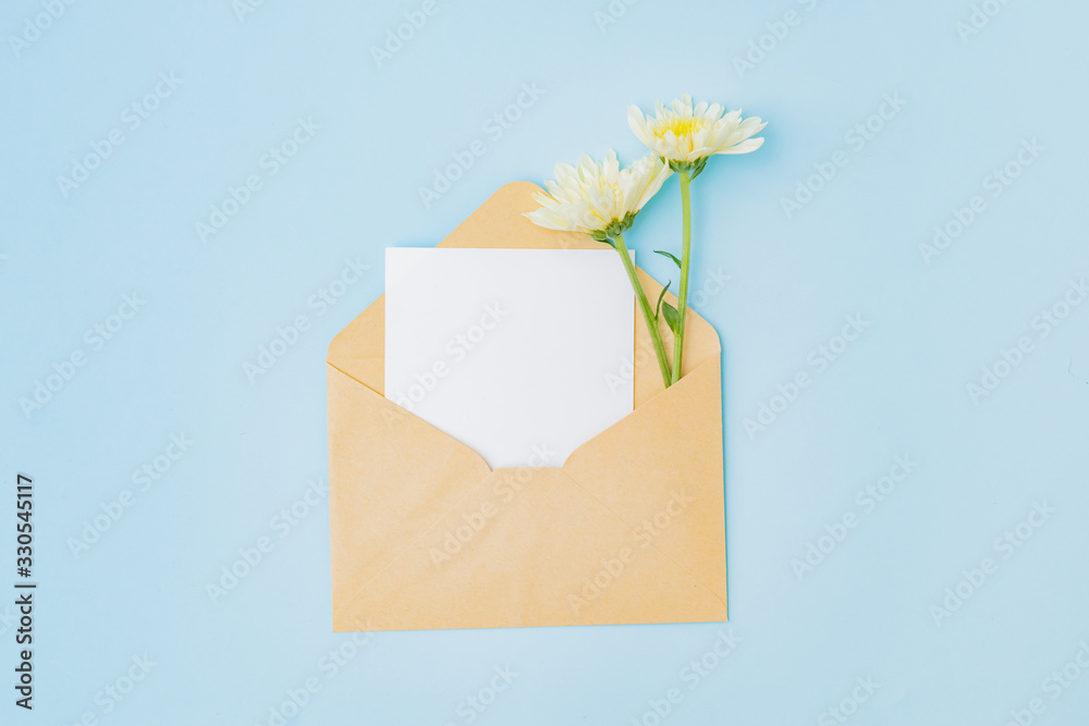 Mockup white greeting card and envelope with flowers on a blue background Mockup white greeting card and envelope with flowers on a blue background