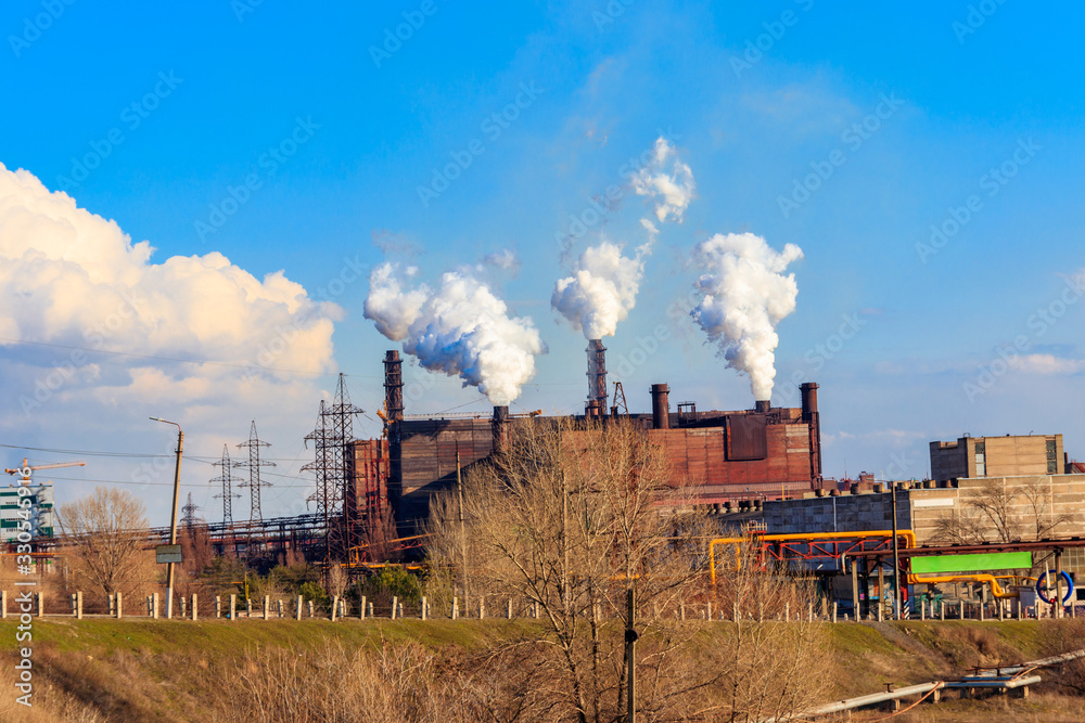 View of old factory with pipes with smoke. Air pollution, environmental damage