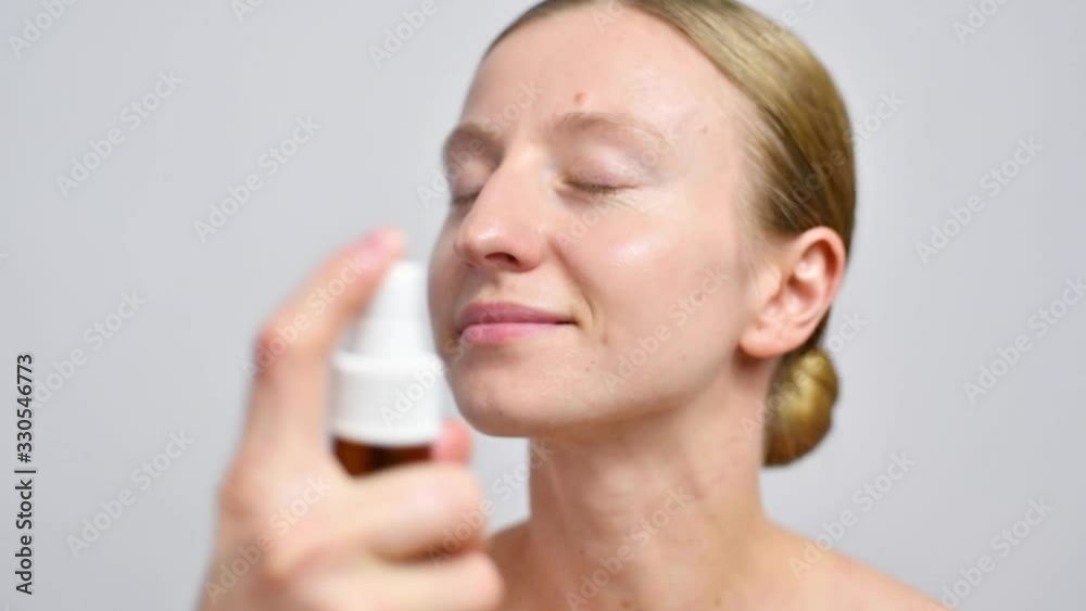 Beautiful woman is spraying micellar water on face Beautiful woman is spraying micellar water on face
