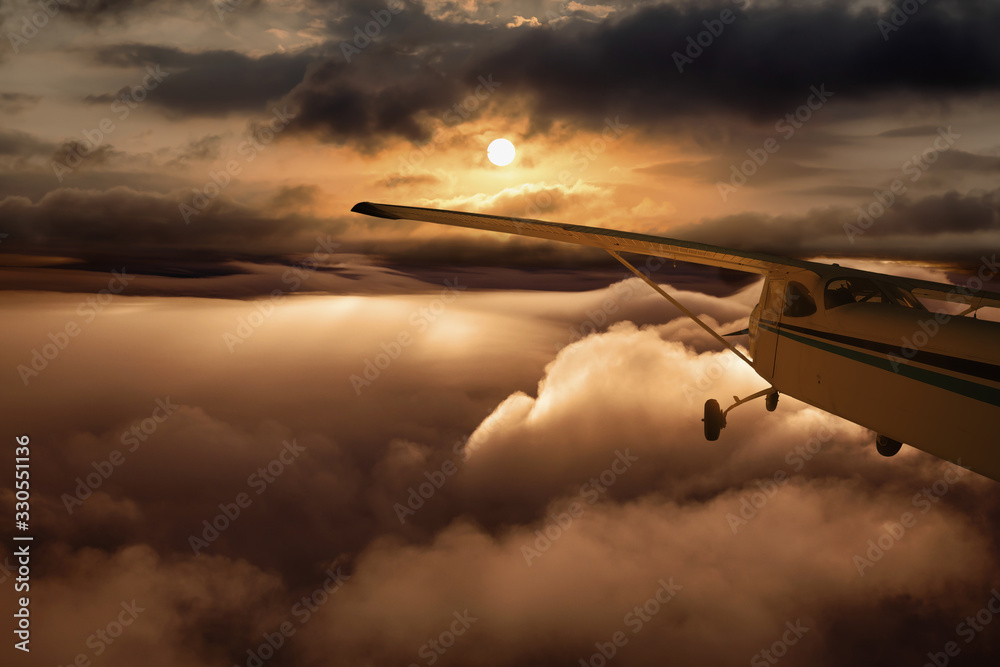 Airplane flying above the clouds during colorful sunset or sunrise. Concept of Travel, transportation, aviation, journey, adventure