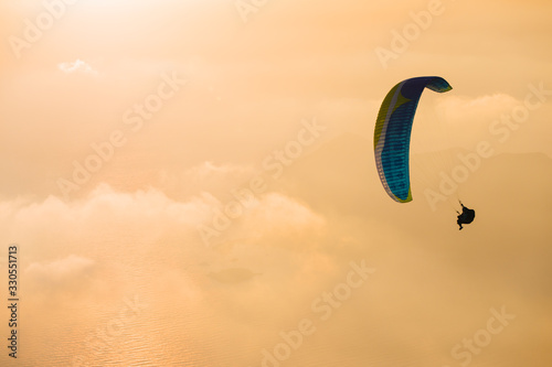 The beauty of paragliding. Extreme sport. Romance of heights. Landscape at sunset. Flying above the clouds. photo