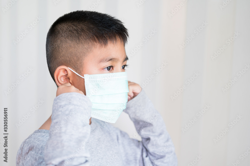 Portrait Asian kid wearing medical mask.A boy wearing mouth mask against air smog pollution. Concept of corona virus quarantine or covid-19.Protection against virus and infection control concept. Portrait Asian kid wearing medical mask.A boy wearing mouth mask against air smog pollution. Concept of corona virus quarantine or covid-19.Protection against virus and infection control concept.