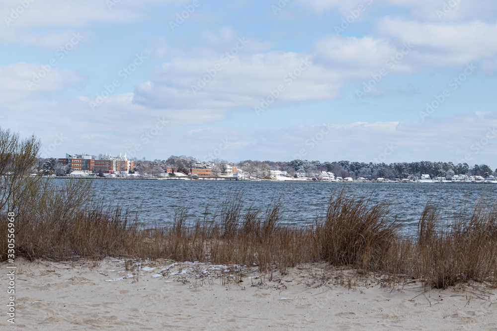 Snow patches along the beach of the riverfront in Yorktown, Virginia, by the inland beach.