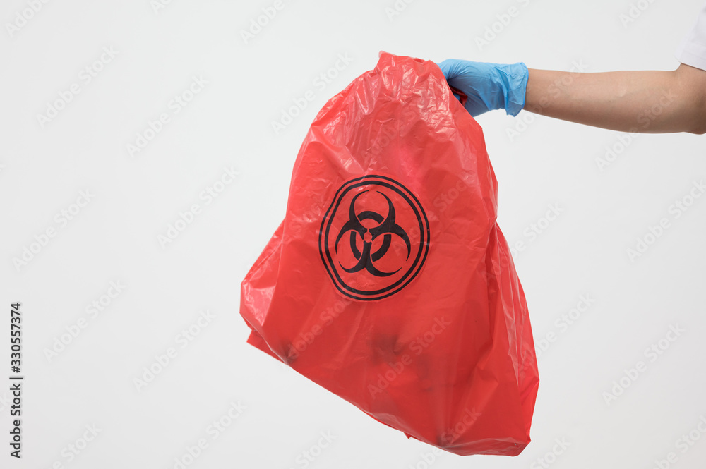 Scientist wearing blue gloves and red bag with bioharzard sign.A woman