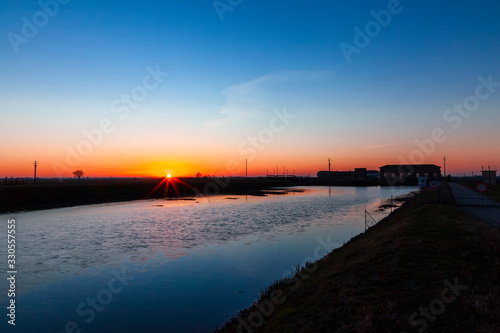 tramonto a Botti Barbarighe, Cavarzere, Venezia, Italia, Veneto. Visibile  Idrovora di Santa Giustina. Bonifica polesana.