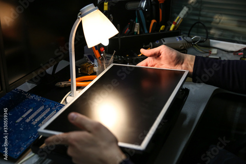 electrician hands are repairing monitor in workshop close up