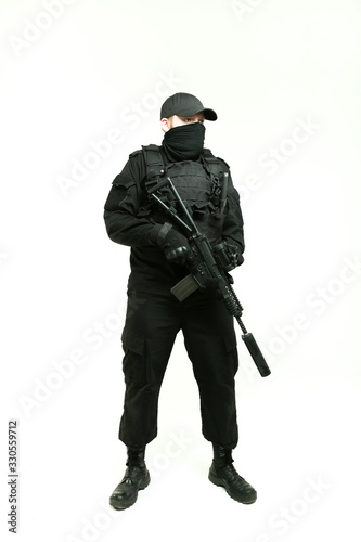  man in a black military uniform holding machine gun and standing full height on white background