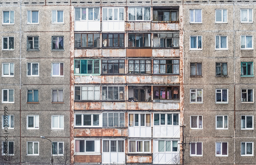 Facade of a grey multi-storey soviet panel building © Lianna Art