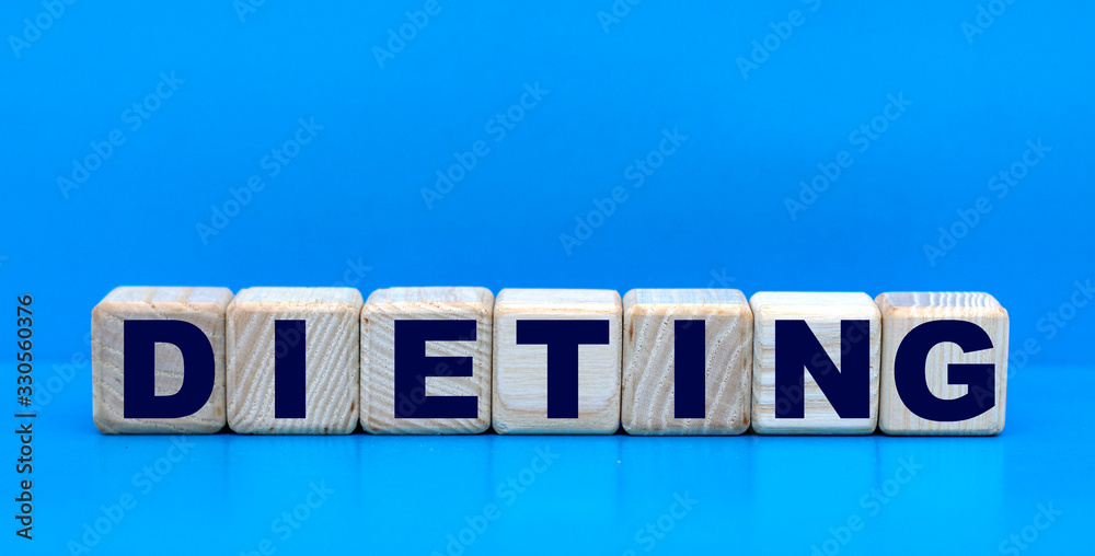 concept word DIETING on cubes on a blue background