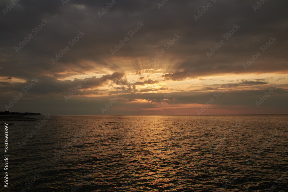 bright and dramatic sunset with many colors and a cloudy sky over the ocean of the Baltic Sea bright and dramatic sunset with many colors and a cloudy sky over the ocean of the Baltic Sea