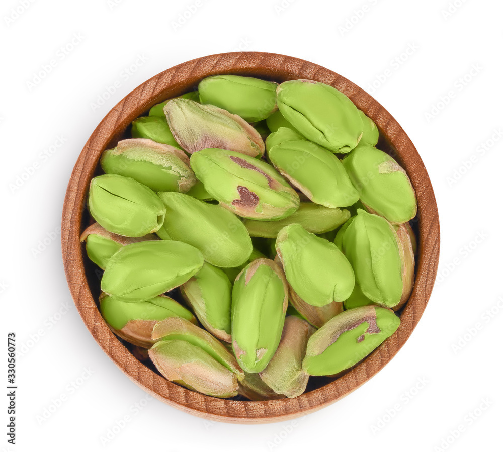 peeled pistachio in wooden bowl isolated on white background with clipping path and full depth of field. Top view. Flat lay peeled pistachio in wooden bowl isolated on white background with clipping path and full depth of field. Top view. Flat lay