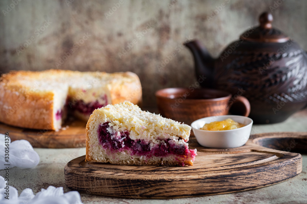 A piece of cherry pie on a wooden plate in the foreground A piece of cherry pie on a wooden plate in the foreground