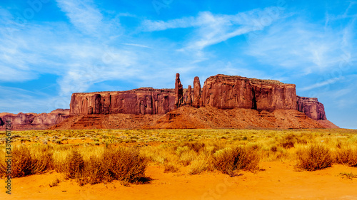 The Three Sisters and Mitchell Mesa, a few of the many massive Red Sandstone Buttes and Mesas in Monument Valley, a Navajo Tribal Park on the border of Utah and Arizona, United States © hpbfotos
