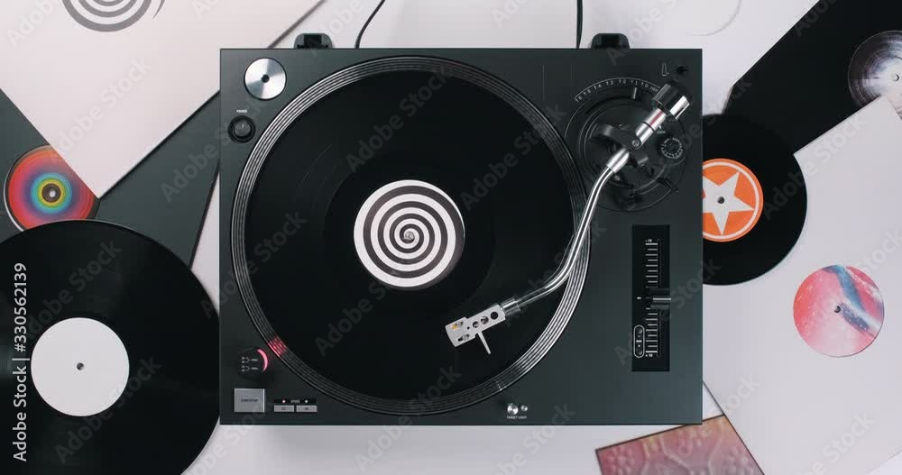 DJ player turntable black vinyl background spiral label in center on white surface with vinyls. Rotating plate close-up. Needle stylus. Loop. Top view. Popular Disco Styles 60s, 70s, 80s, 90s. Party