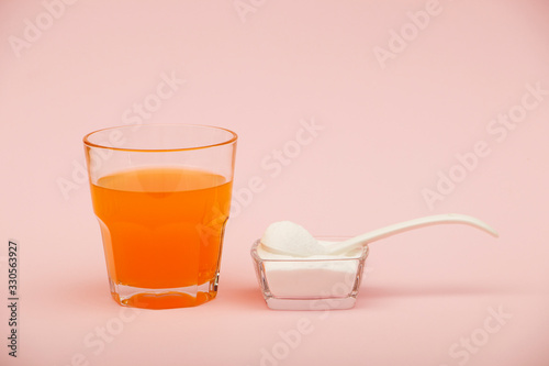 Collagen powder on pink background. Extra protein intake. Natural beauty and health supplement for skin, bones, joints and gut. Plant or fish based. Flatlay, top view. Copy space for your text.