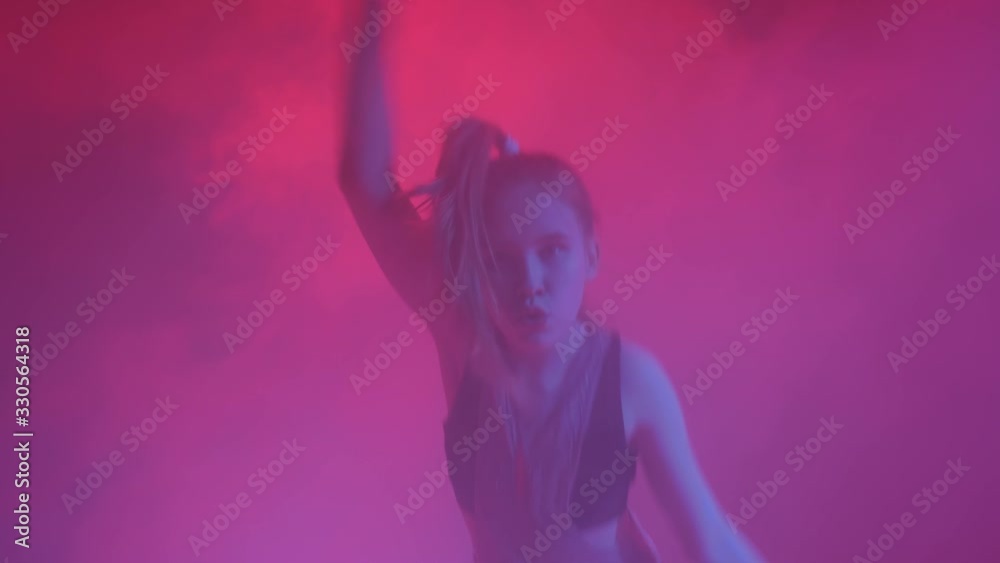 Young stylish girl dancing in the Studio on a colored neon background. Music dj poster design. Young stylish girl dancing in the Studio on a colored neon background. Music dj poster design.