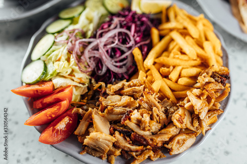 Doner Kebab on plate with vegetables fries and souce, grilled meat on plate photo