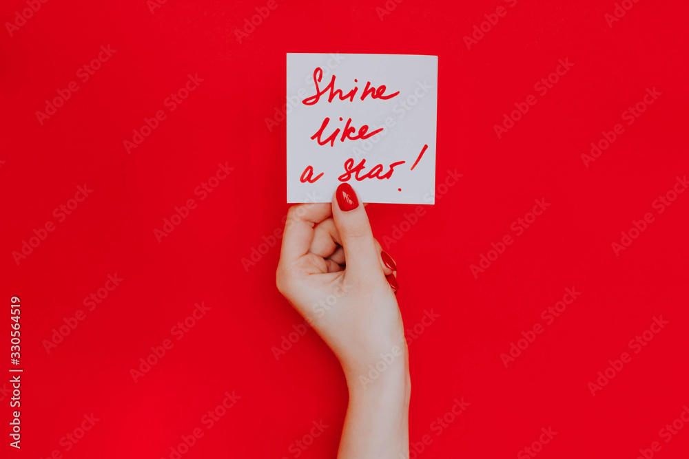 Note in a female hand with manicure, red nails. Note in a female hand with manicure, red nails.