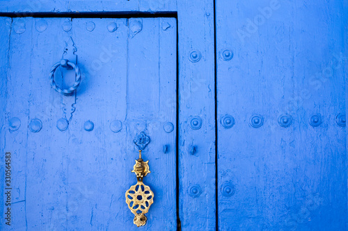 Background of traditional powder blue painted door with golde doorknocker © WH_Pics