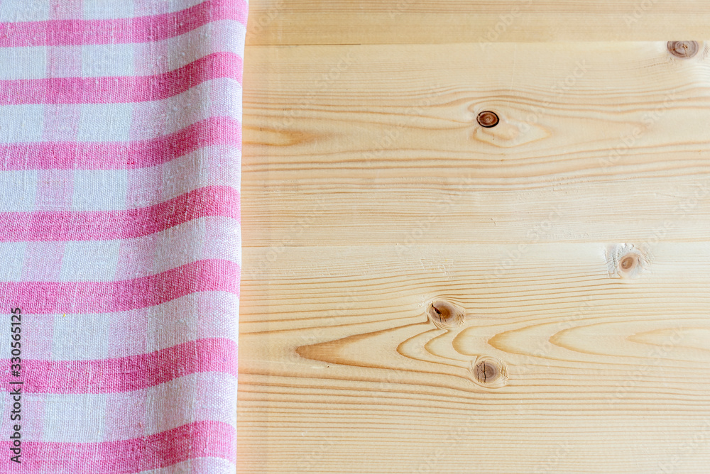 Background with checkered pink napkin on a wooden table. Copy space.