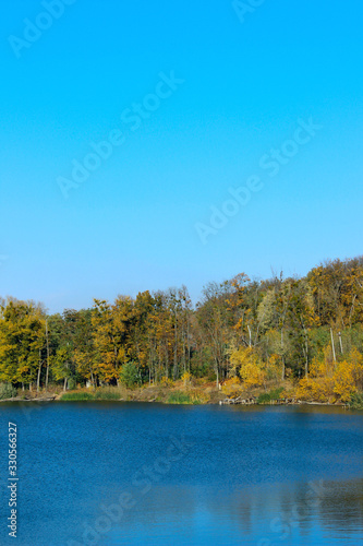 Lake, blue sky and forest, vertical view. Beautiful landscape. Abstract nature background.