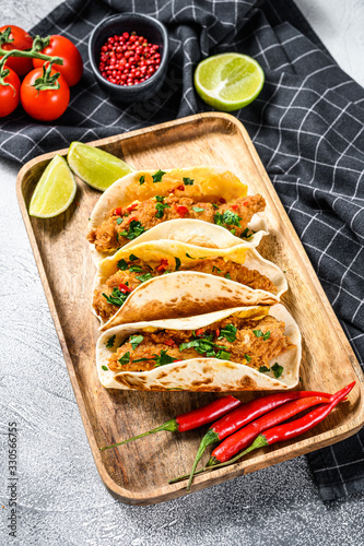 Tacos with crispy chicken, parsley, cheese and chili peppers. White background. Top view