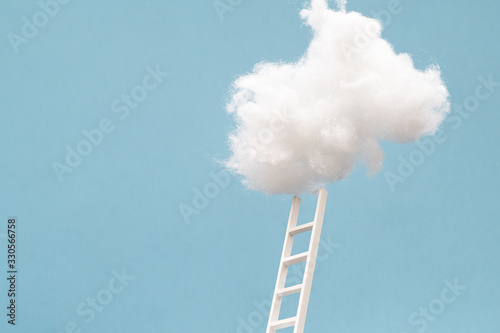 ladder leading up to a puffy cotton cloud on a blue background.