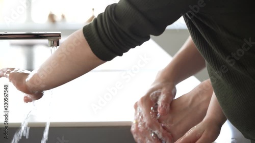 Little boy is washing hands together with his mother - she is teaching him Aboud good hygiene photo