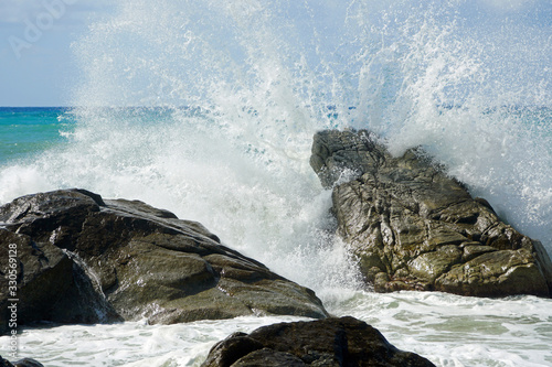 Sea waves bouncing onto rocks creating shower of water droplets photo