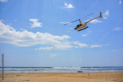 Inspirational and picturesque view of a helicopter taking off over Sri Lankan beach. Sri Lanka beaches on Bentota, Indian Ocean photo