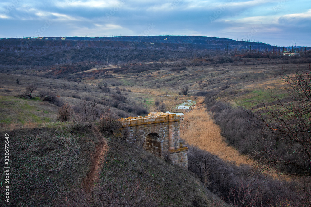 The ruins of an ancient bridge. Landscape.
