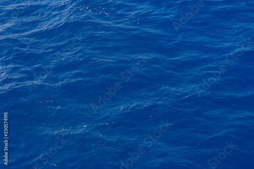 Clean pure Mediterranean sea surface with a lot of tiny waves, bubbles and foam. Copy space background.