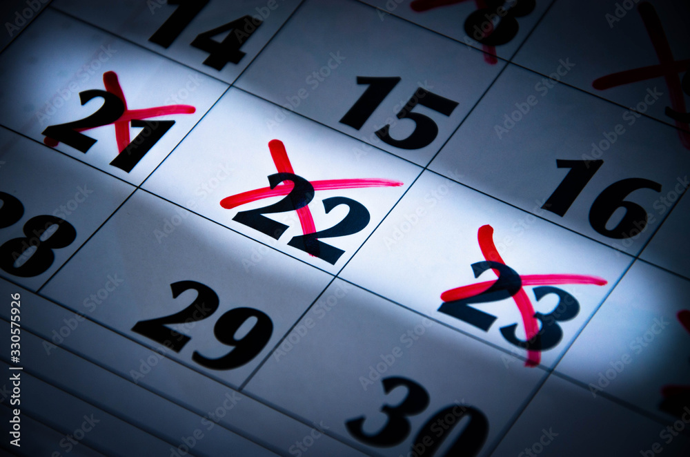 A hand draws a circle on the number 16 on the calendar with a red marker. Crossed out numbers. Highlighted numbers by light. Calendar for plans, notes, meetings. Business calendar. Copy Space A hand draws a circle on the number 16 on the calendar with a red marker. Crossed out numbers. Highlighted numbers by light. Calendar for plans, notes, meetings. Business calendar. Copy Space
