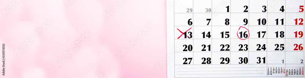 A cross with a red marker on the calendar at number 13 on a pink background. Mark on the calendar with a red marker. Calendar for plans, notes, meetings. Business calendar.  Copy Space