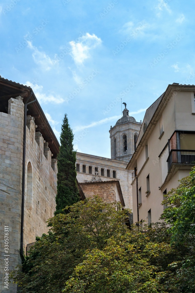 Girona, Spain, August 2018. Medieval architecture on a background of blue cloudy sky.