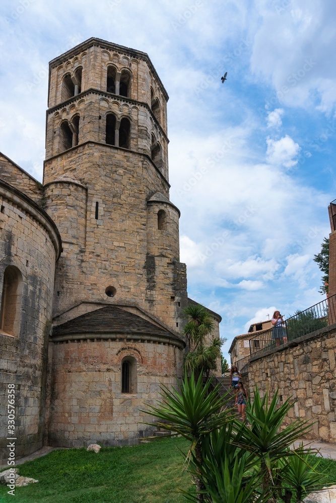 Girona, Spain, August 2018. The tower of the monastery of St. Peter Galligans against a cloudy sky.