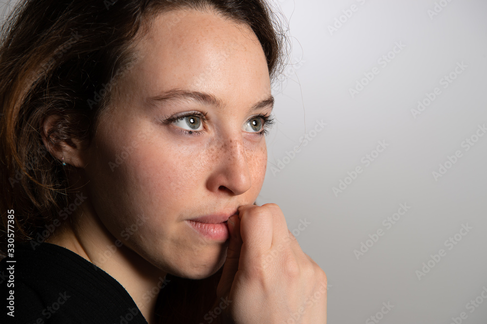 Sideview of thoughtful worrying pretty girl leaning hand on her face. Fear and hesitant face expression, emotions... Sideview of thoughtful worrying pretty girl leaning hand on her face. Fear and hesitant face expression, emotions...